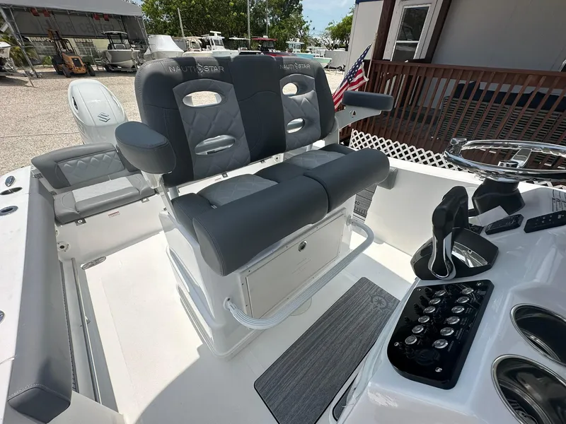 Slide: The Image of 2024 NauticStar 252 boat interior with dual captain's chairs and control panel. - 3
