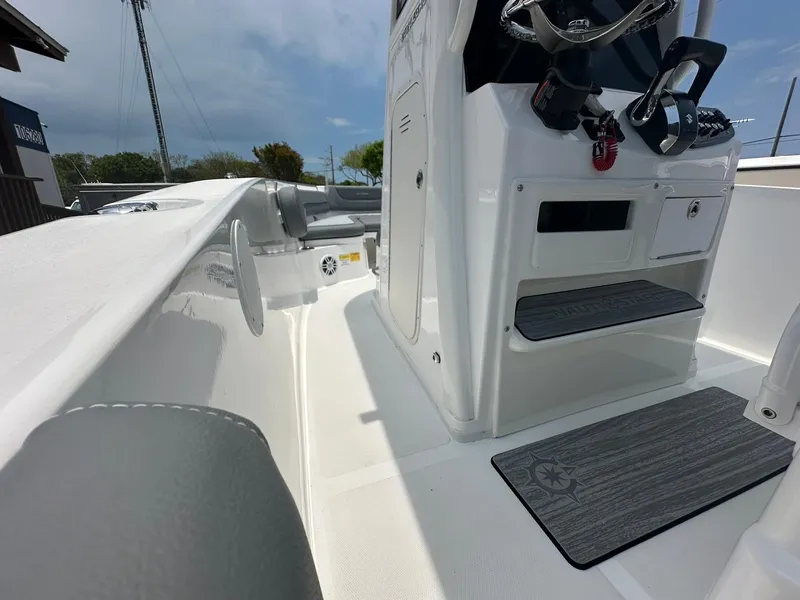 Slide: The Image of 2024 NauticStar 252 boat interior with steering console and seating area. - 5