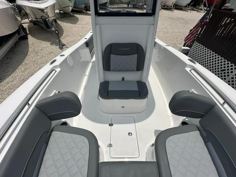 Slide: The Image of 2024 NauticStar 252 boat interior with cushioned seating and storage compartments. - 7
