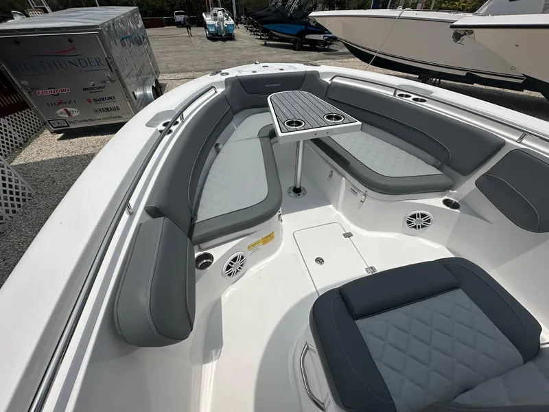 Slide: The Image of 2024 NauticStar 252 boat interior with gray seating and table. - 9