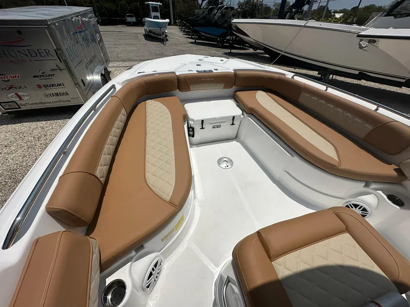 Slide: The Image of 2024 NauticStar 251 boat with tan and white cushioned seating. - 11