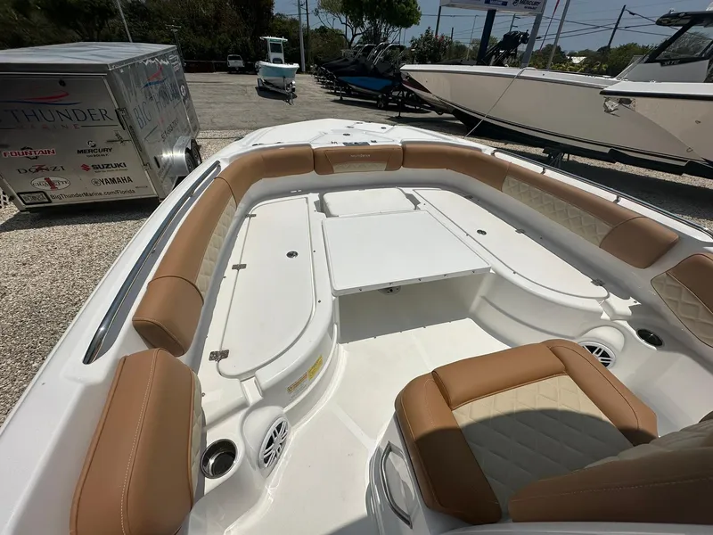 Slide: The Image of 2024 NauticStar 251 boat with tan and white seating in a marina. - 13