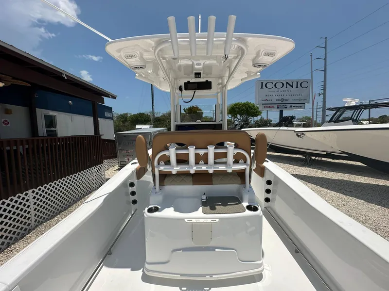 Slide: The Image of 2024 NauticStar 251 boat interior with rod holders and seating, displayed outdoors. - 18
