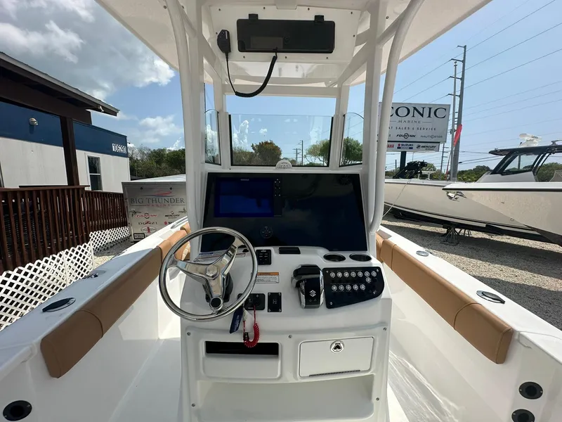 Slide: The Image of 2024 NauticStar 251 boat console with steering wheel and navigation controls. - 2