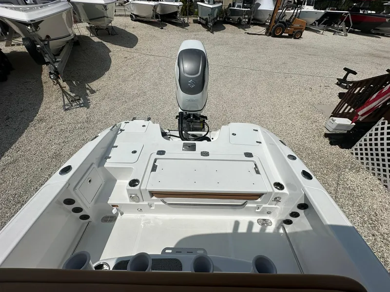 Slide: The Image of 2024 NauticStar 251 boat with outboard motor, rear deck view in a boatyard. - 21
