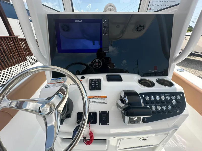 Slide: The Image of 2024 NauticStar 251 boat dashboard with steering wheel, controls, and navigation screen. - 4