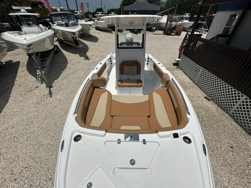 Slide: The Image of 2024 NauticStar 251 boat with tan seating, displayed in a boat dealership. - 6