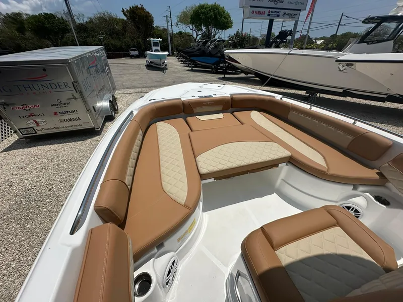 Slide: The Image of 2024 NauticStar 251 boat with tan and cream seating in a showroom. - 8