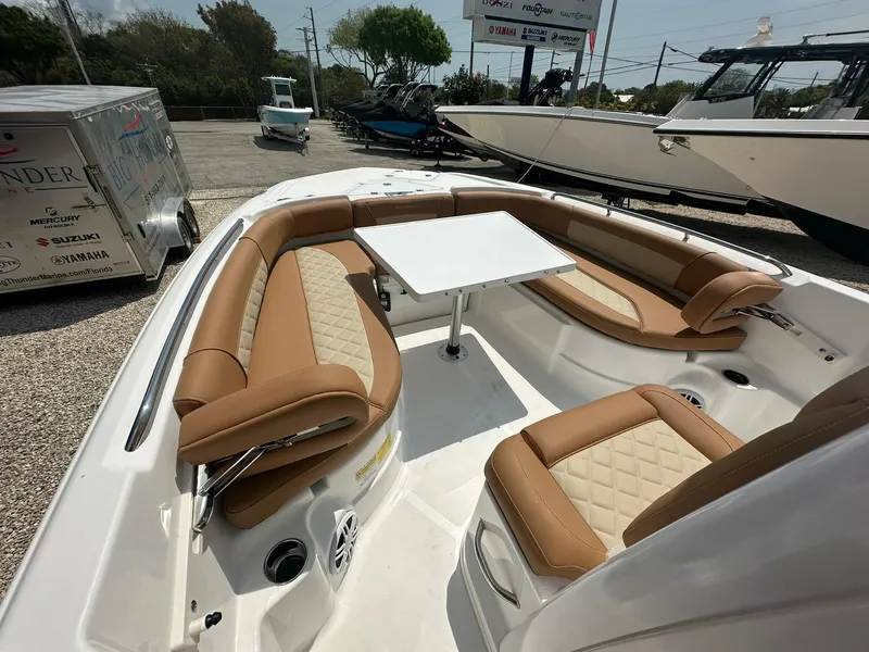 Slide: The Image of 2024 NauticStar 251 boat with tan seating and a white table in the bow area. - 9