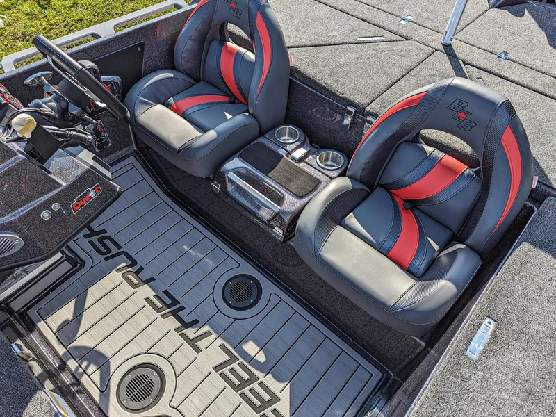 Slide: The Image of 2025 Bass Cat Jaguar boat interior with black and red seats and Feel the Rush floor mat. - 11