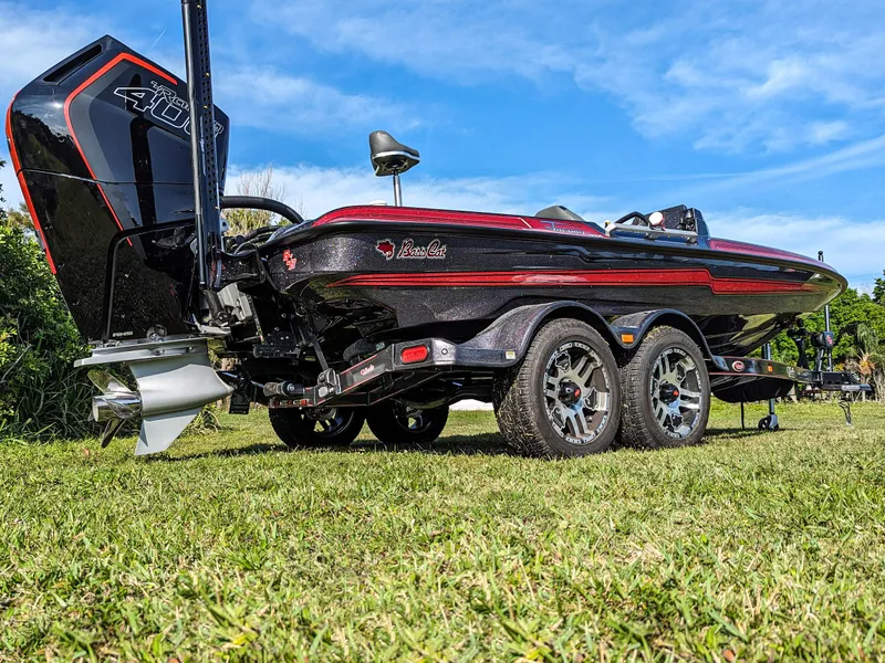 Slide: The Image of 2025 Bass Cat Jaguar boat with powerful engine on a grassy field. - 14