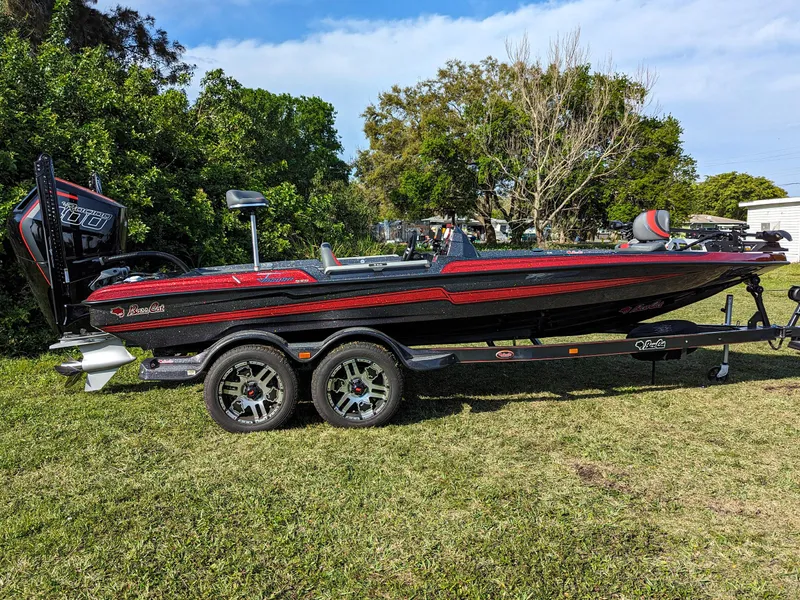 Slide: The Image of 2025 Bass Cat Jaguar boat on calm water with a person at the helm. - 2