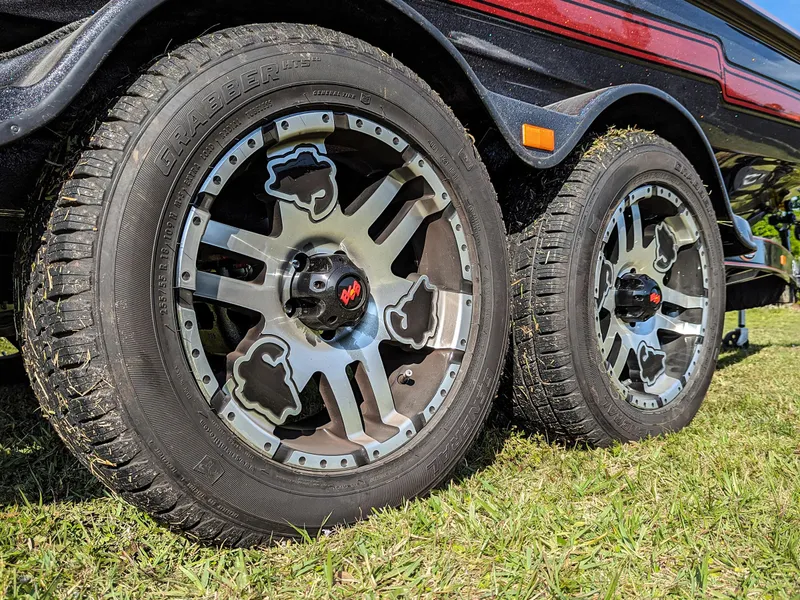 Slide: The Image of Close-up of 2025 Bass Cat Jaguar trailer wheels on grass. - 6