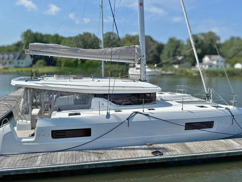 Slide: The Image of 2025 Lagoon 43 catamaran docked at a marina, featuring sleek design and modern amenities. - 0