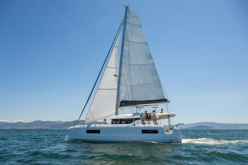 Slide: The Image of 2025 Lagoon 43 catamaran sailing on open sea under clear blue sky. - 5