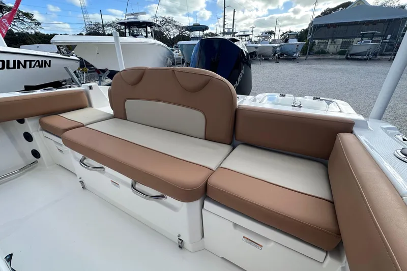 Slide: The Image of 2024 NauticStar 222 boat interior with tan and cream cushioned seating. - 12