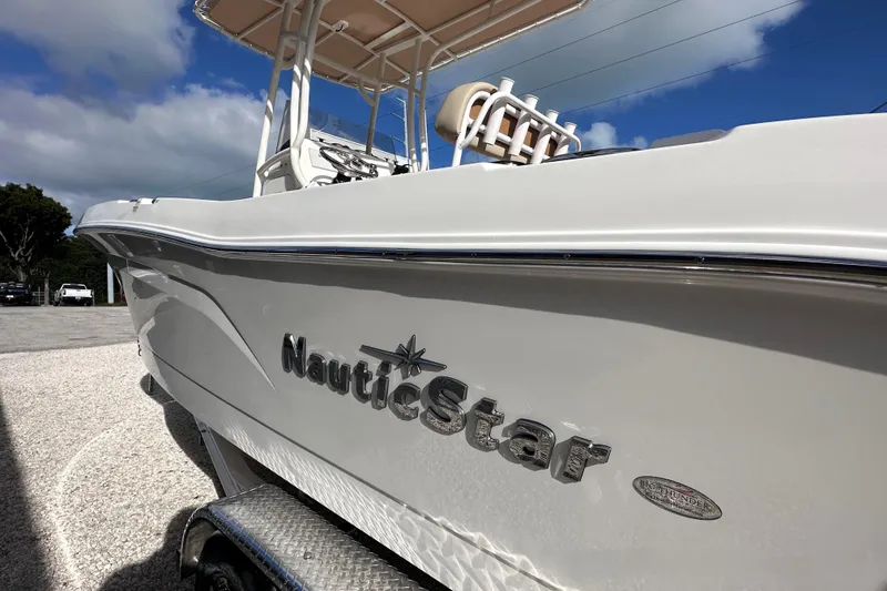 Slide: The Image of 2024 NauticStar 222 boat with sleek design and logo, parked outdoors. - 3