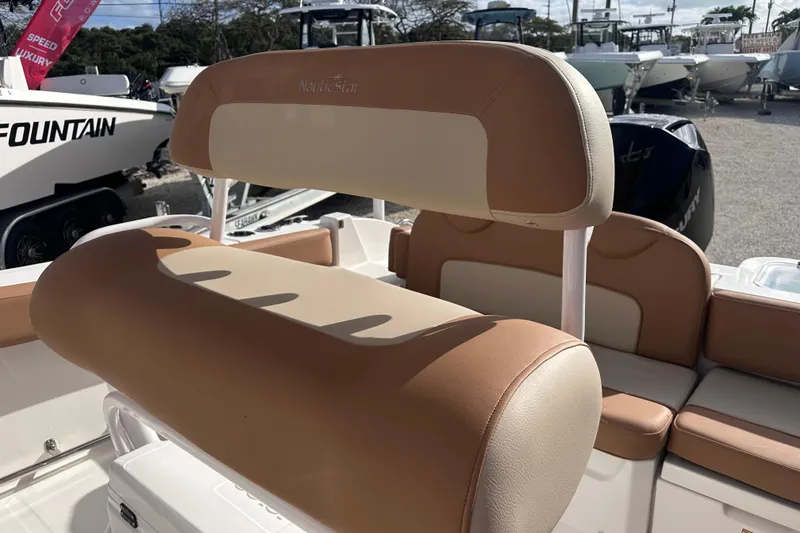 Slide: The Image of 2024 NauticStar 222 boat with tan and cream seating, displayed outdoors. - 5