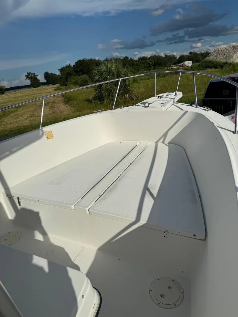 Slide: The Image of 1989 Pursuit 230 Center Console boat, spacious deck, sunny day, grassy background. - 4