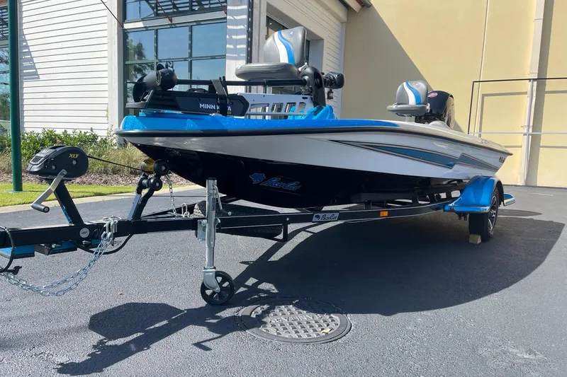 Slide: The Image of 2024 Bass Cat Bobcat Vision fishing boat on trailer, blue and white exterior. - 3