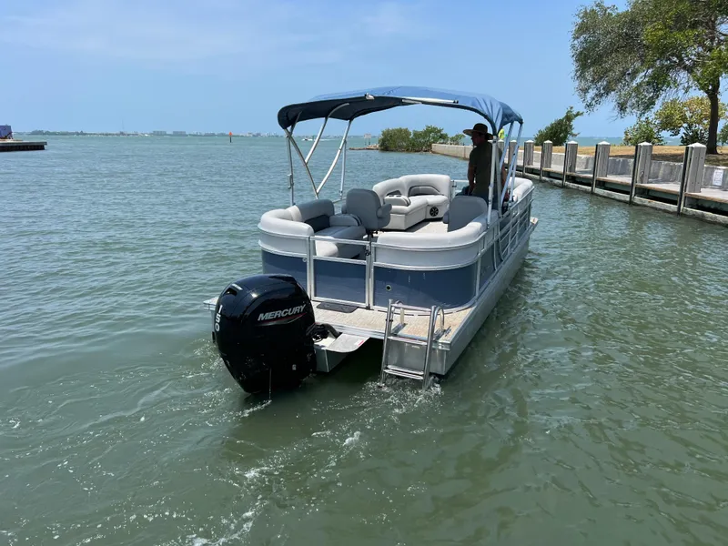 Slide: The Image of 2023 Landau Island Breeze 232 pontoon boat on the water with a Mercury outboard motor. - 15