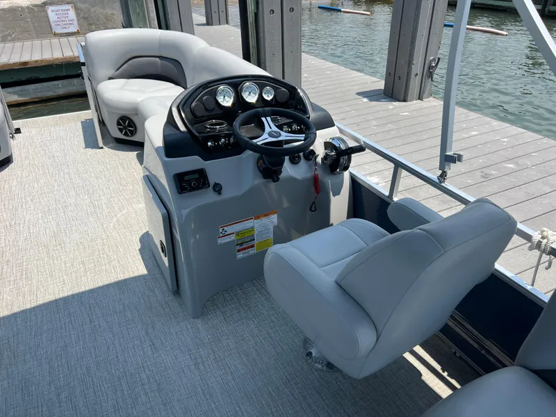 Slide: The Image of 2023 Landau Island Breeze 232 boat interior with steering console and seating. - 3