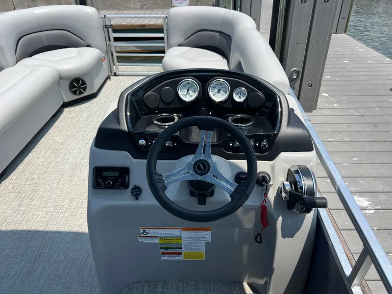 Slide: The Image of 2023 Landau Island Breeze 232 pontoon boat helm with steering wheel and dashboard controls. - 8