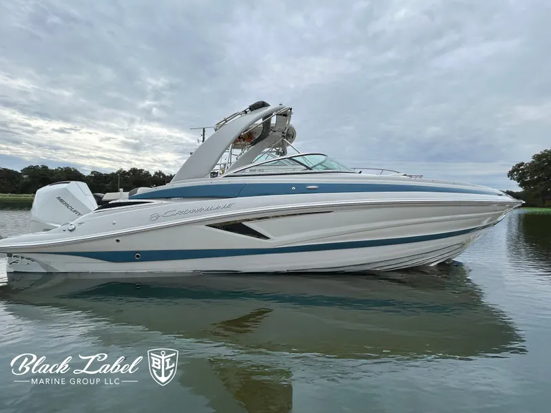 Slide: The Image of 2024 Crownline 270 XSS boat on calm water, overcast sky. - 0