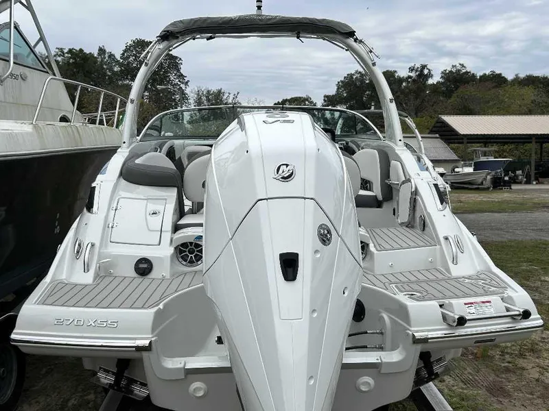 Slide: The Image of 2024 Crownline 270 XSS boat, rear view, docked outdoors. - 1