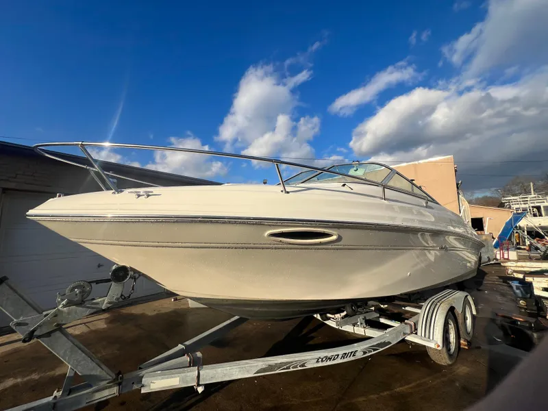 Slide: The Image of 1998 Sea Ray 210 Cuddy Cabin boat on trailer under a blue sky. - 10