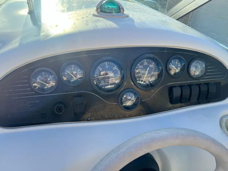 Slide: The Image of 1998 Sea Ray 210 Cuddy Cabin dashboard with gauges and controls. - 13
