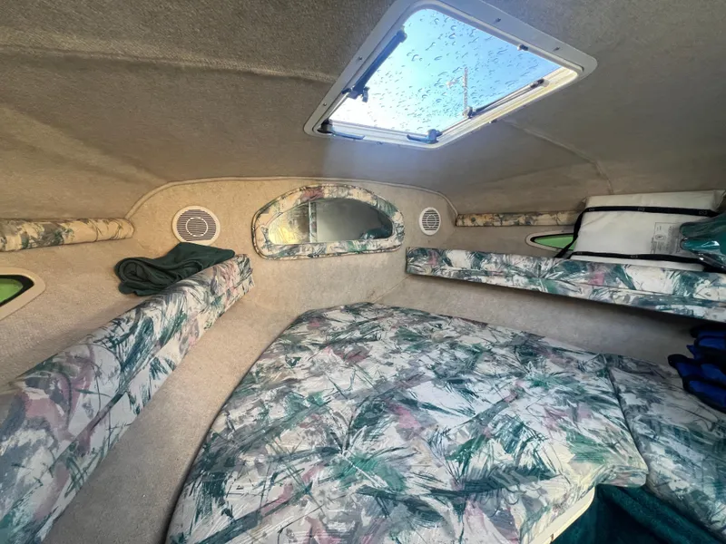 Slide: The Image of 1998 Sea Ray 210 Cuddy Cabin interior with floral upholstery and overhead hatch. - 14
