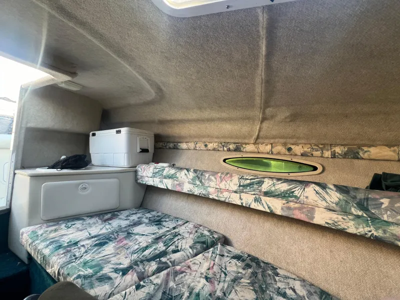 Slide: The Image of 1998 Sea Ray 210 Cuddy Cabin interior with patterned cushions and compact storage. - 15