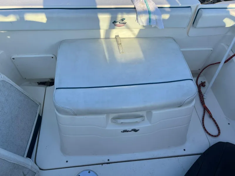 Slide: The Image of 1998 Sea Ray 210 Cuddy Cabin boat interior with cushioned seating and storage. - 18