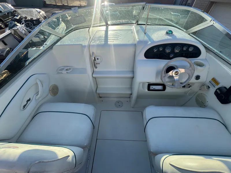 Slide: The Image of 1998 Sea Ray 210 Cuddy Cabin boat interior with steering wheel and seating. - 19