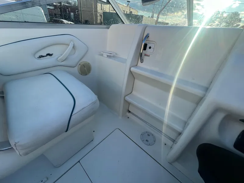 Slide: The Image of 1998 Sea Ray 210 Cuddy Cabin interior with white seating and storage compartments. - 21