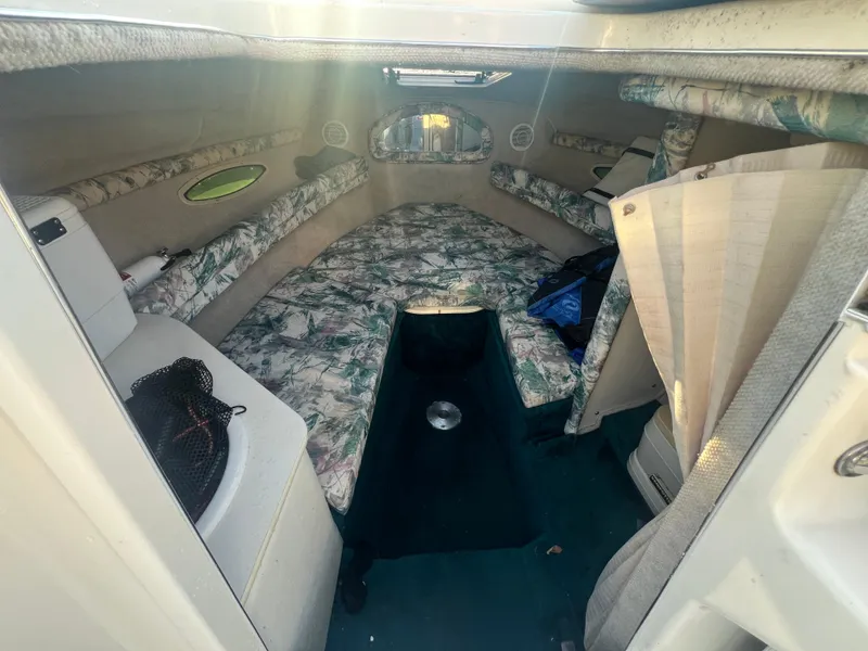 Slide: The Image of 1998 Sea Ray 210 Cuddy Cabin interior with floral upholstery and compact design. - 23