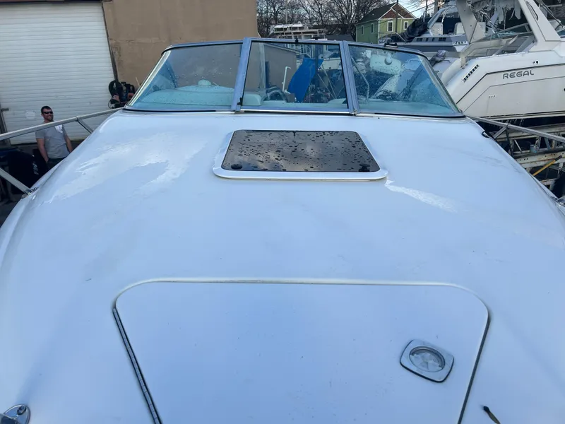 Slide: The Image of 1998 Sea Ray 210 Cuddy Cabin boat, white exterior, docked near other vessels. - 3