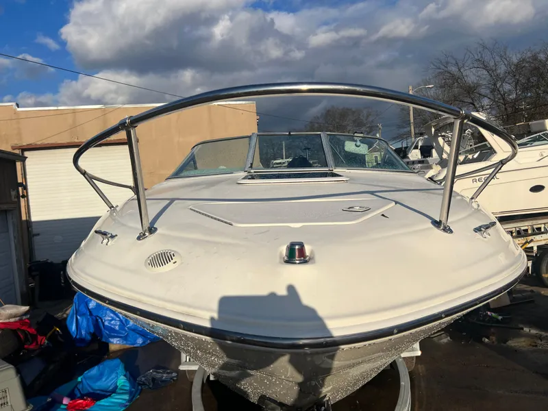 Slide: The Image of 1998 Sea Ray 210 Cuddy Cabin boat, front view, parked outdoors under cloudy sky. - 4