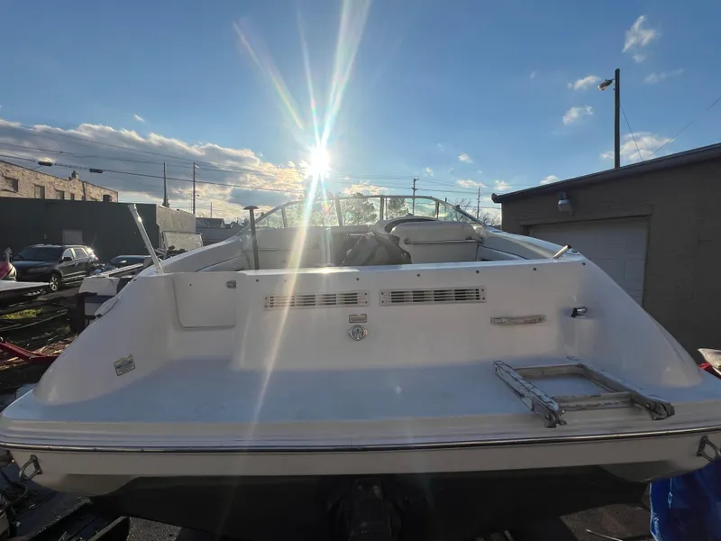 Slide: The Image of 1998 Sea Ray 210 Cuddy Cabin boat, rear view, under bright sun. - 8