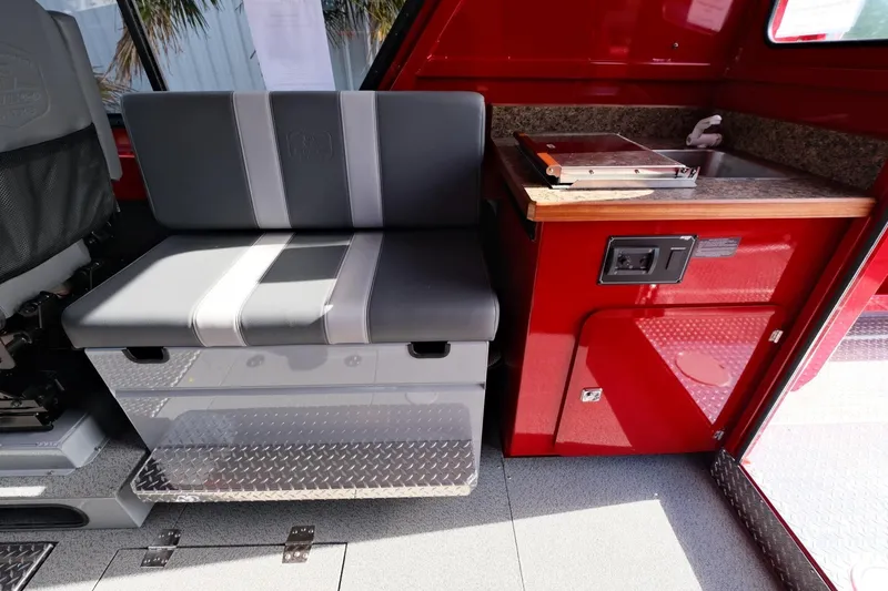 Slide: The Image of 2024 Hewescraft 270 Alaskan interior with seating and kitchenette area. - 17