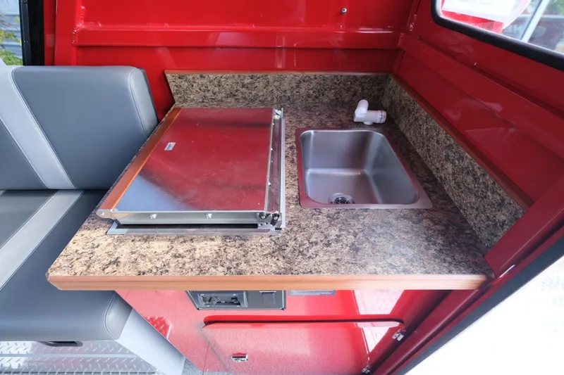 Slide: The Image of 2024 Hewescraft 270 Alaskan interior with compact kitchen sink and stove. - 19