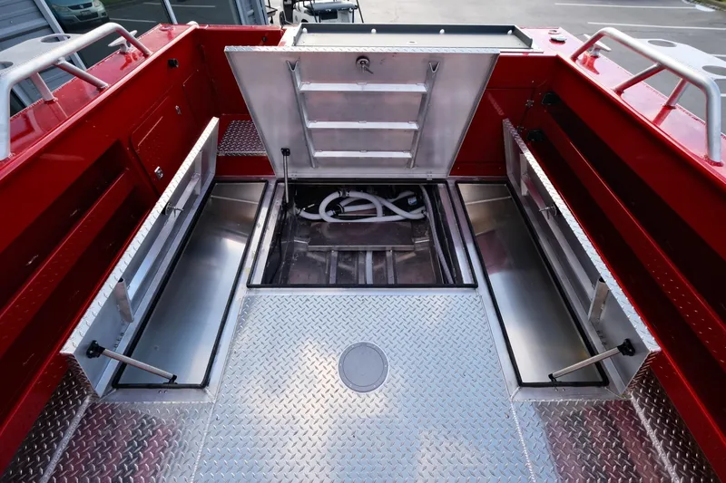 Slide: The Image of 2024 Hewescraft 270 Alaskan boat storage compartments with open hatches and diamond plate flooring. - 21