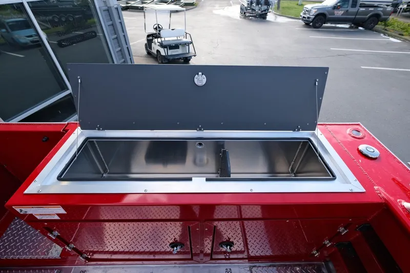 Slide: The Image of 2024 Hewescraft 270 Alaskan boat with open storage compartment, red exterior, parked in lot. - 22