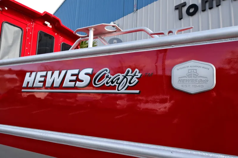 Slide: The Image of 2024 Hewescraft 270 Alaskan boat, red exterior, close-up of logo and badge. - 23