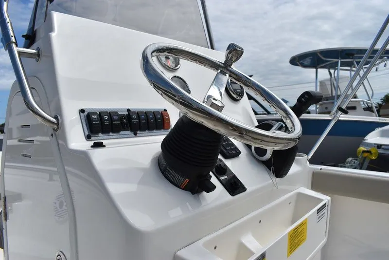 Slide: The Image of 2024 Key West 189 FS boat steering console with controls and chrome wheel. - 27