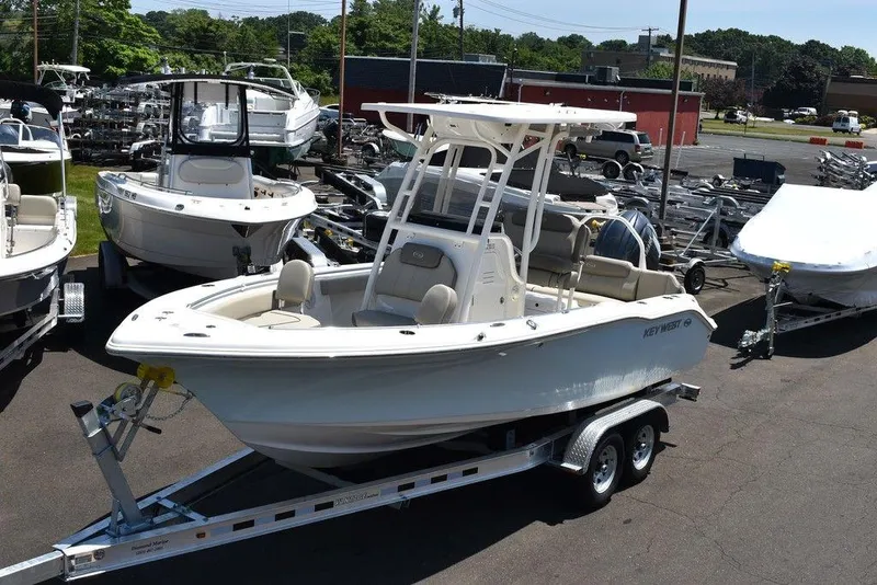 The Image of 2024 Key West 219 FS boat on a trailer in a dealership lot. - 1