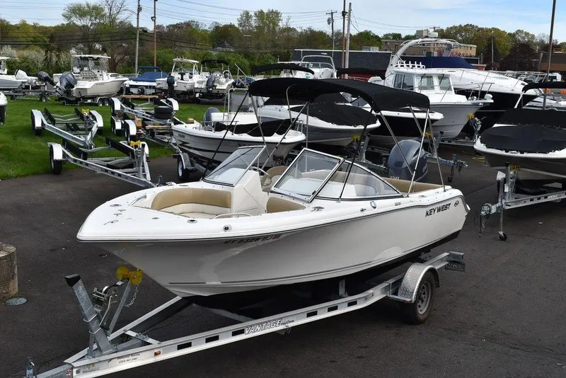 Slide: The Image of 2018 Key West 203DFS boat on a trailer in a marina. - 1
