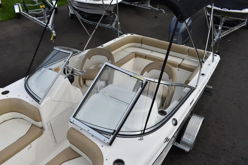 Slide: The Image of 2018 Key West 203DFS boat with beige and white interior, dual consoles, and seating area. - 16
