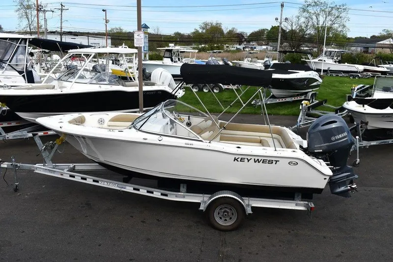 Slide: The Image of 2018 Key West 203DFS boat on a trailer in a marina. - 6